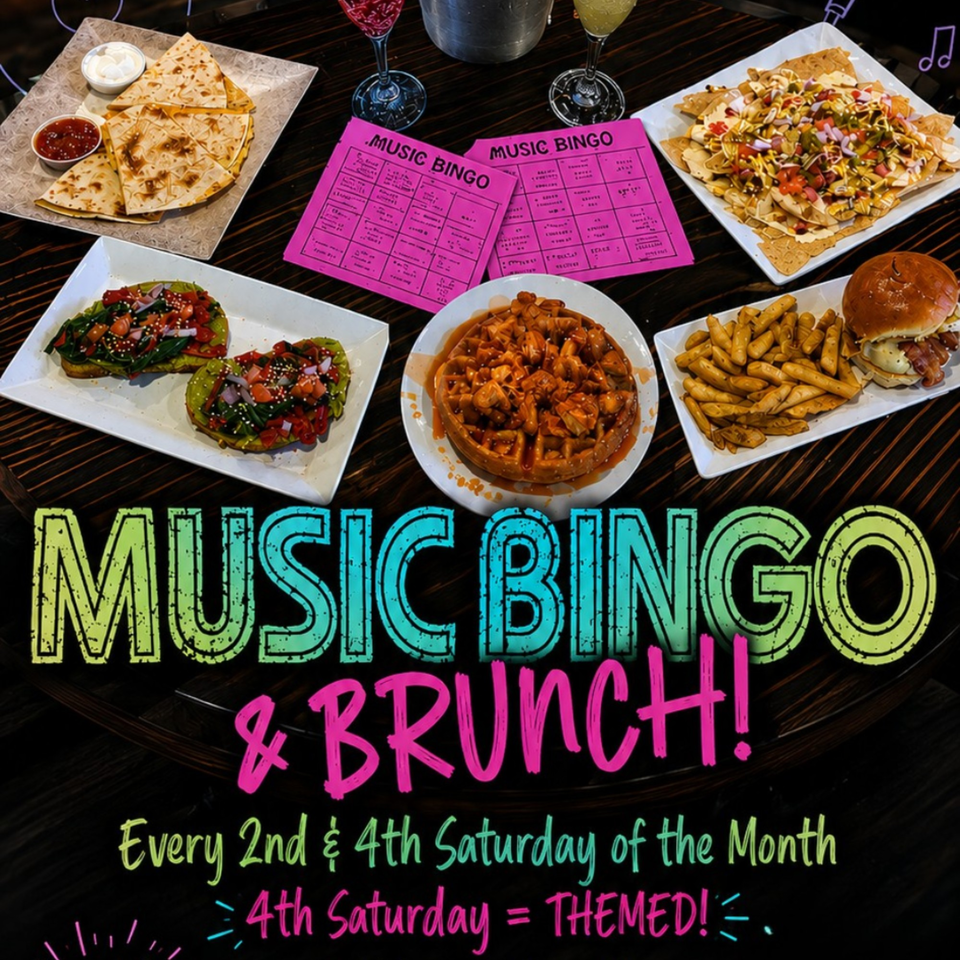 A table spread with quesadillas, avocado toast, nachos, chicken and waffles, a burger, and fries.