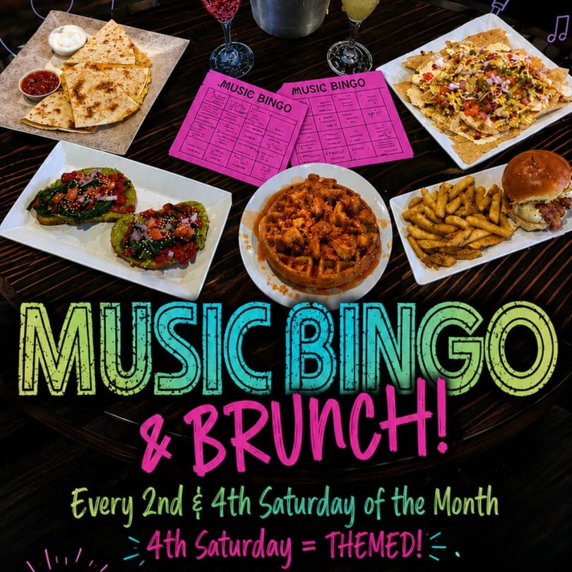 A table spread with quesadillas, avocado toast, nachos, chicken and waffles, a burger, and fries.