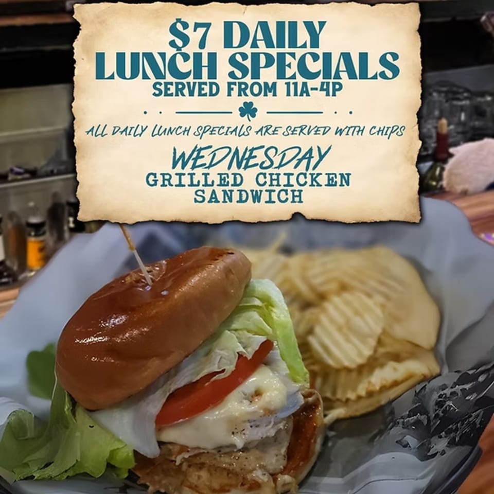 Gleasons Bar's grilled chicken sandwich with lettuce, tomato, and cheese, served with chips.