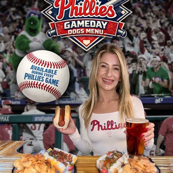 A woman holds a hot dog and beer in front of a Phillies Gameday Dogs Menu banner and baseball stadium crowd.